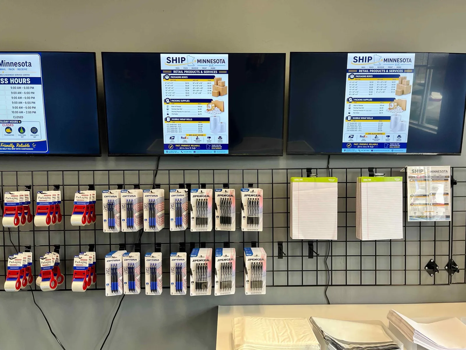 Retail wall at Ship Minnesota with posted box and supply prices, pens, packing tape and legal pads