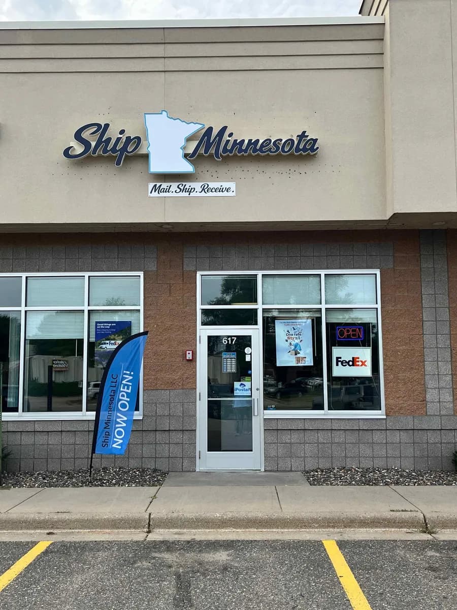 Ship Minnesota storefront at 617 Locust Street with a Now Open flag